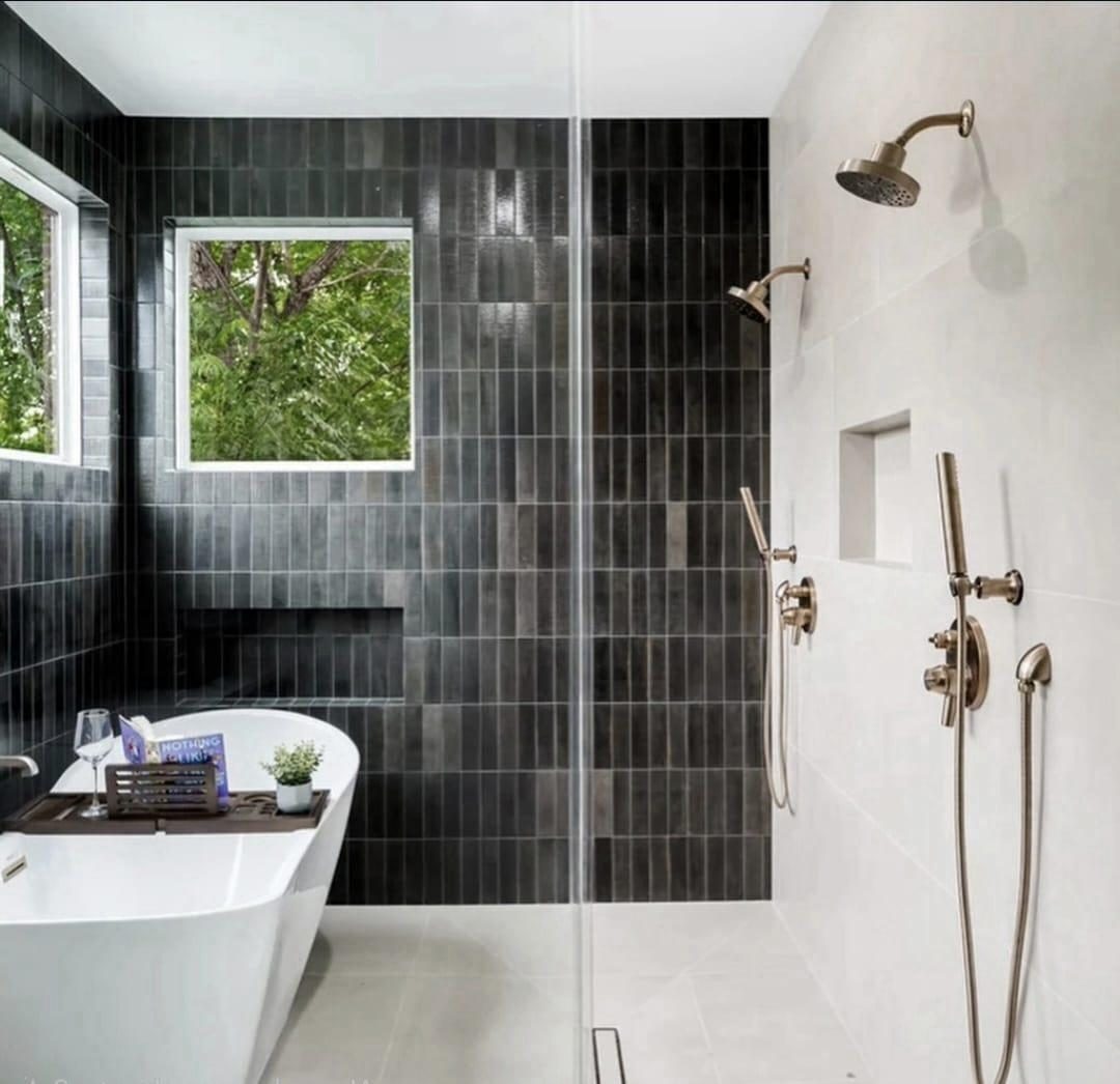 Primary bath with black tile, freestanding tub and walk-in shower