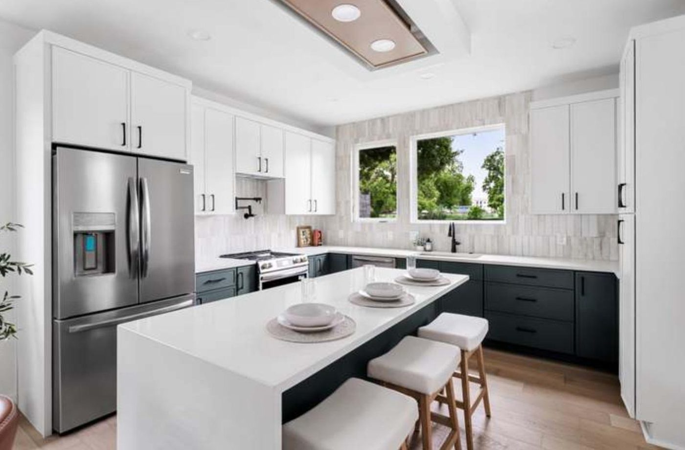Kitchen with waterfall island and navy cabinetry